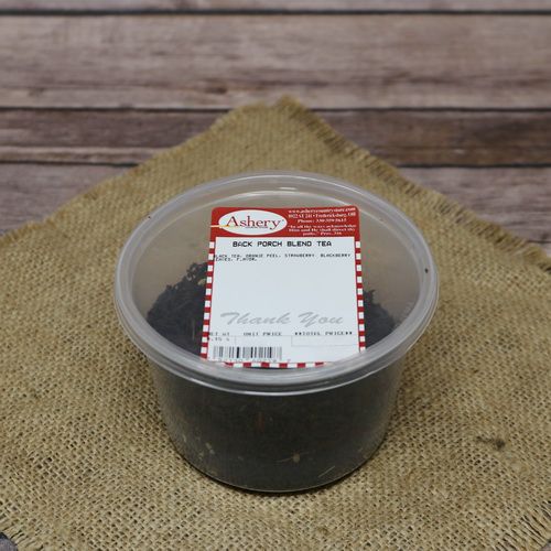 A clear plastic container of Back Porch Blend Tea on rustic burlap with a wooden background.