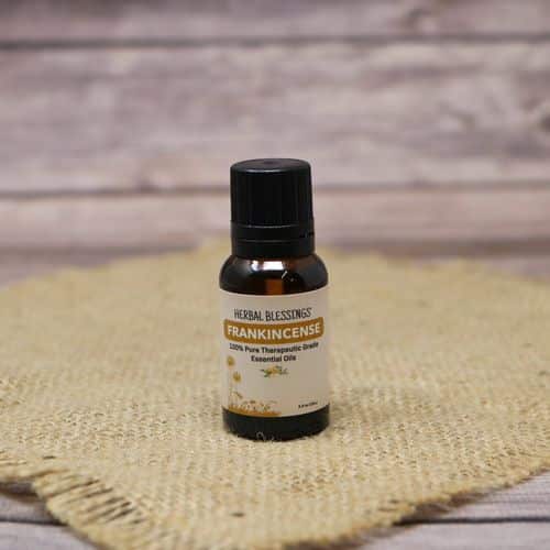 A 0.5 oz bottle of Frankincense Oil, set on rustic burlap with a wooden background.