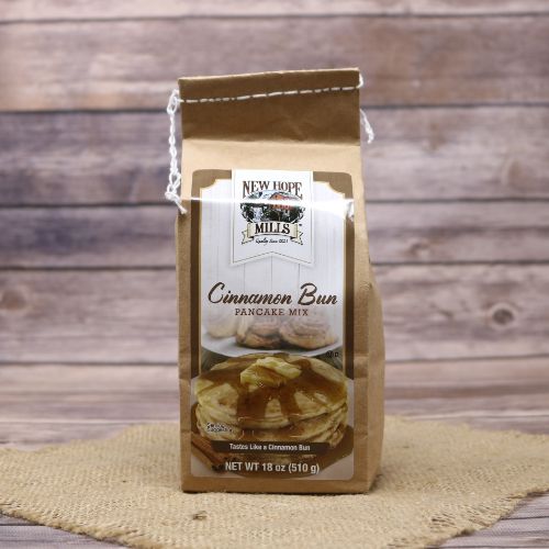 Bag of Cinnamon Bun Pancake Mix on rustic burlap with a wooden background.
