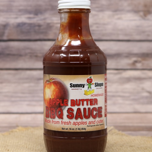 A bottle of Sunny Slope Apple Butter BBQ Sauce with a white lid.
