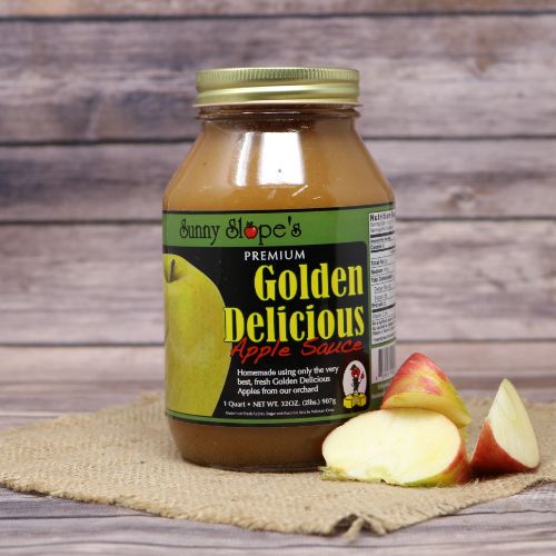 A quart size glass jar of Sunny Slope Orchards Golden Delicious Apple Sauce, on rustic burlap with a wooden background.