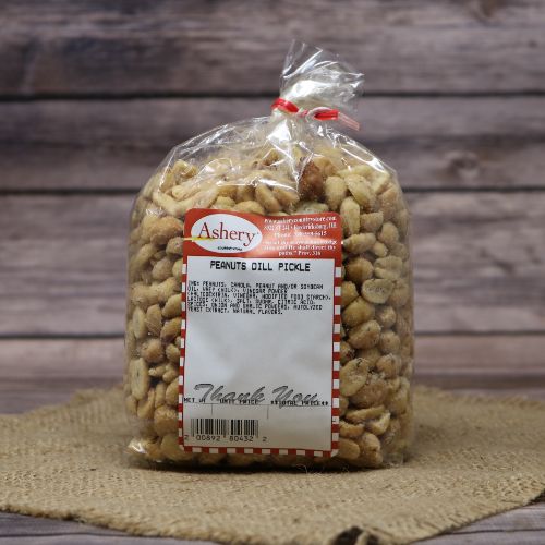 A plastic bag of Dill Pickle Peanuts, closed with a twist tie and set on rustic burlap with a wooden background.