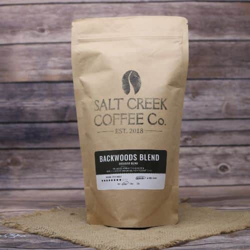 Coffee in brown paper bag against rustic wood background