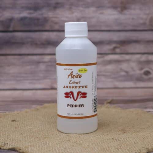 Small 8oz plastic bottle of clear liquid with a white and green sticker label, sitting on a burlap material with wood background