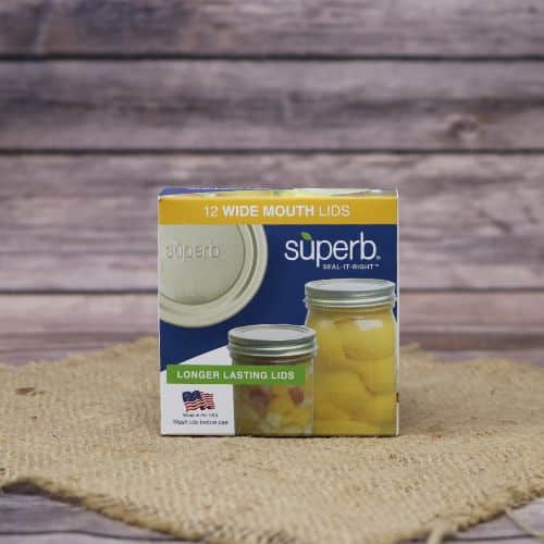 A 12 count box of Superb Wide Mouth Canning Lids, on rustic burlap with a wooden background.