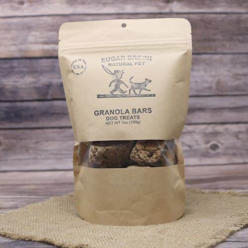 Brown paper bag with old fashioned looking logo of a boy and a dog, with the contents showing through a clear plastic window on the bag
