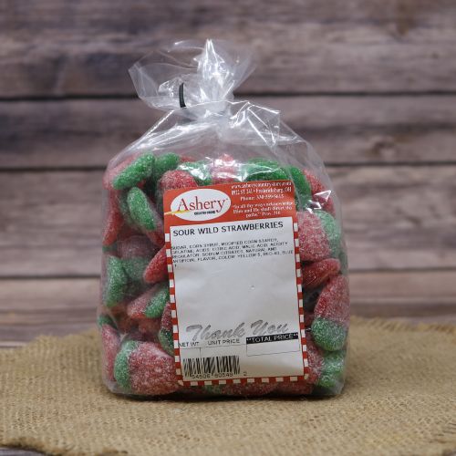 A bag of Ashery Sour Wild Strawberries candy, with a mix of red and green sugary pieces, set against a burlap mat and wood textured background.