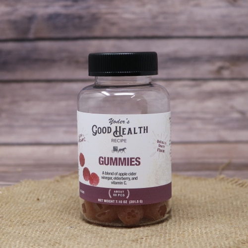 A bottle of Yoder's Good Health Gummies, on rustic burlap with a wooden background.