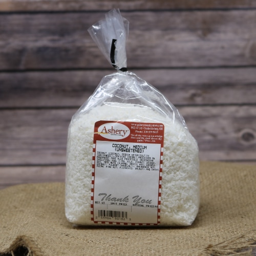 A clear plastic bag with Coconut Medium Unsweetened sealed with a black twist tie on rustic burlap with a wooden background.