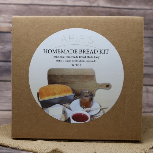 A brown box with a round logo sticker containing a complete Homemade Bread Kit White on rustic burlap with a wooden background.