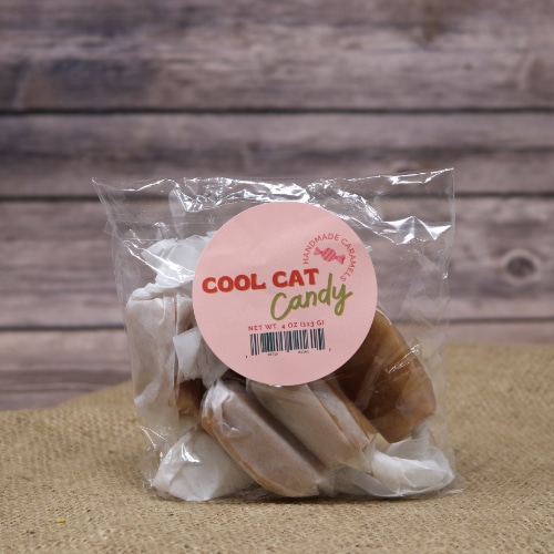 A clear 4 oz bag of individually wrapped Handmade Caramels on rustic burlap with a wooden background.