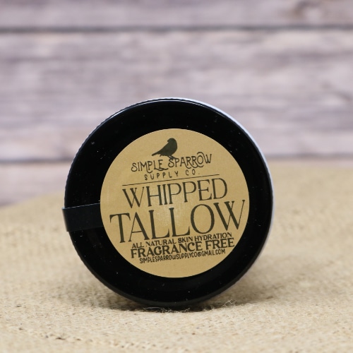A small glass container of Whipped Beef Tallow Frangrance Free on rustic burlap with a wooden background.