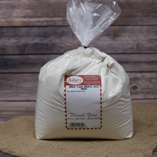 A bag of Bread Flour Organic Ohio Grown on rustic burlap with a wooden background.
