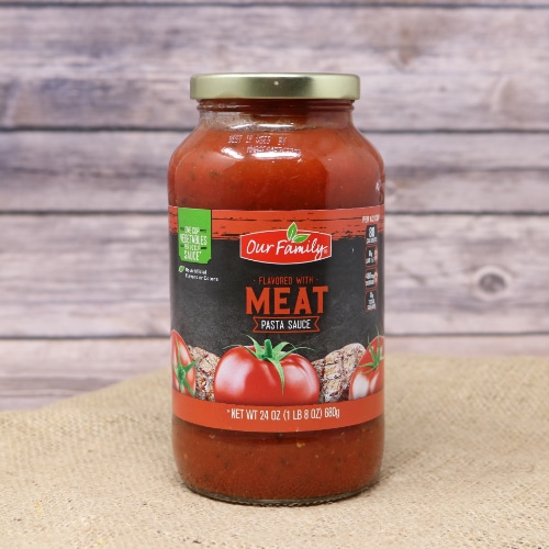 A jar of Meat Pasta Sauce on rustic burlap with a wooden background.