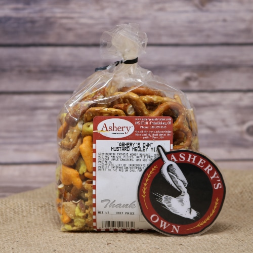 A clear plastic bag of Mustard Medley Mix Ashery's Own sealed with a black twist tie on rustic burlap with a wooden background.