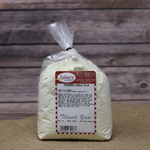 A clear plastic bag of Powdered Whole Milk sealed with a black twist tie on rustic burlap with a wooden background.