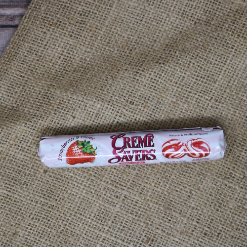 A small thin package containing 12 individually wrapped Creme Savers Strawberry on rustic burlap with a wooden background.