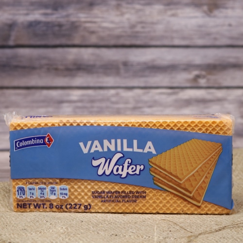 A thin narrow package of Vanilla Wafer Cookies, they are filled with vanilla flavored cream on rustic burlap with a wooden background.