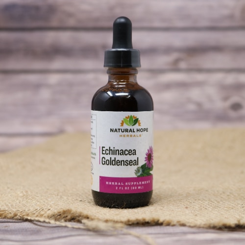 A small glass bottle with a squeeze dropper of Echinacea Goldenseal, displayed on a burlap cloth with a wooden background.