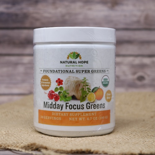 A 30 serving size white round container with an orange label of Midday Focus Greens on rustic burlap with a wooden background.